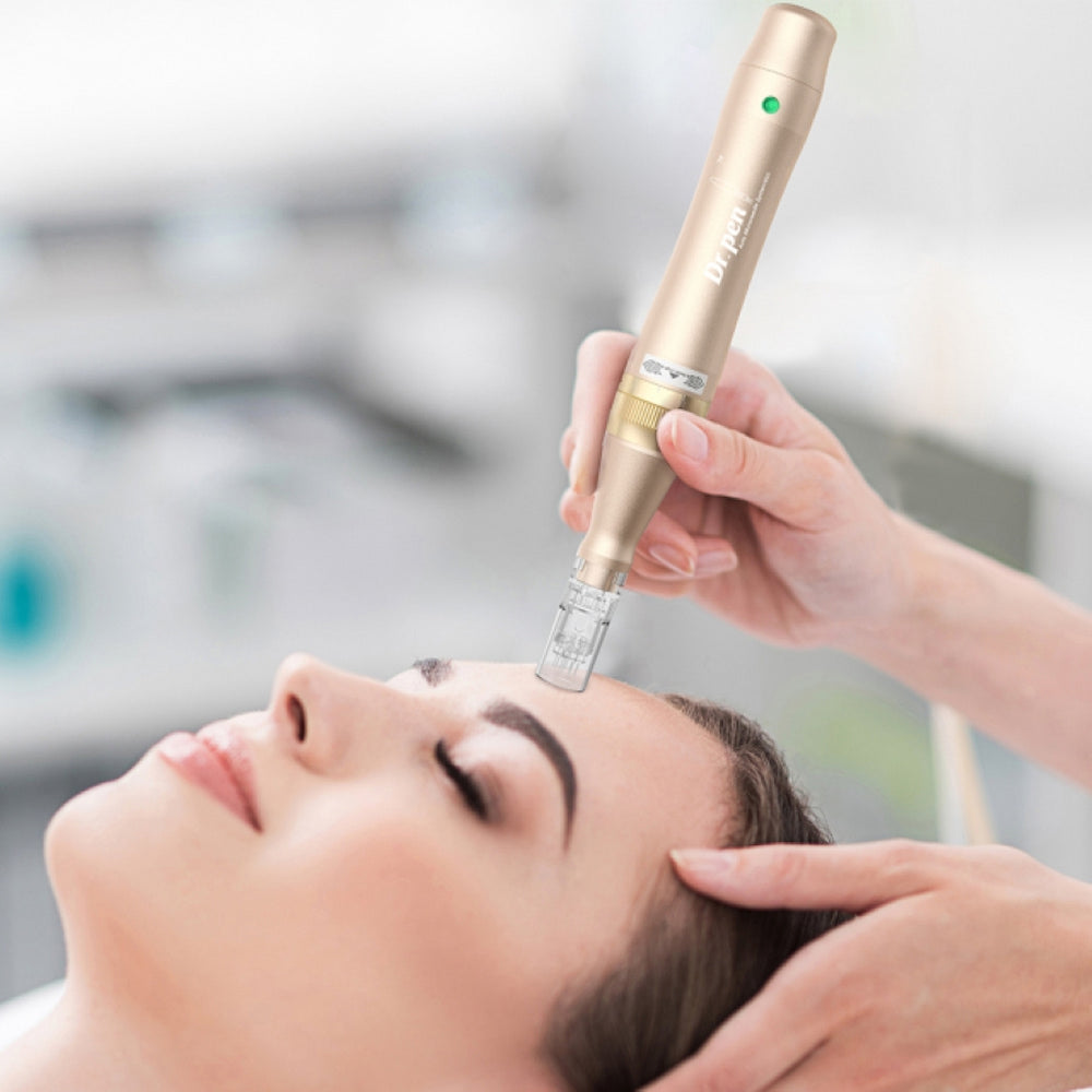 Henkilö makaa rentoutuneena, kun hoitaja suorittaa microneedling otsassa kultaisen värisellä Dr. Pen M5:llä. Hoitaja pitää kynää molemmin käsin tarkkuuden vuoksi.