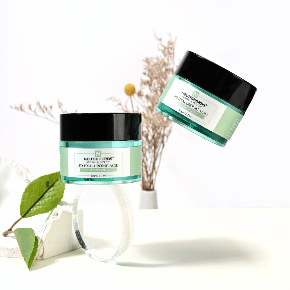 Lifestyle-kuva tuotteesta Neutriherbs 4D Hyaluronic Acid Gel Moisturizer 50 g. Kaksi kosteuttavan geelivoiteen purkkia on esillä vaaleassa ja tyylikkäässä ympäristössä luonnollisilla yksityiskohdilla, jotka välittävät raikasta ihonhoitorutiinia ja intensiivistä kosteutusta.